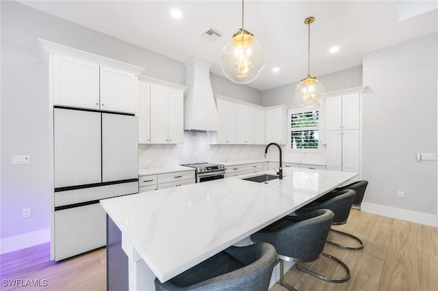 kitchen featuring white cabinetry, custom exhaust hood, electric stove, refrigerator, and sink