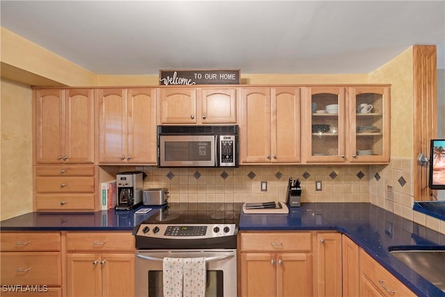 kitchen with backsplash, light brown cabinetry, and appliances with stainless steel finishes