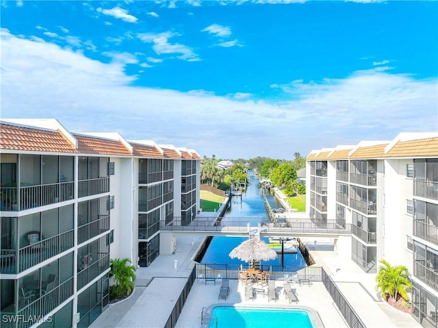 view of swimming pool featuring a patio area and a water view