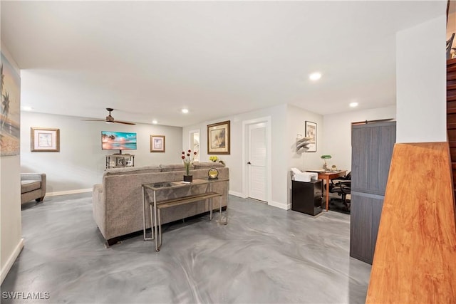 living room featuring a barn door, ceiling fan, and concrete flooring