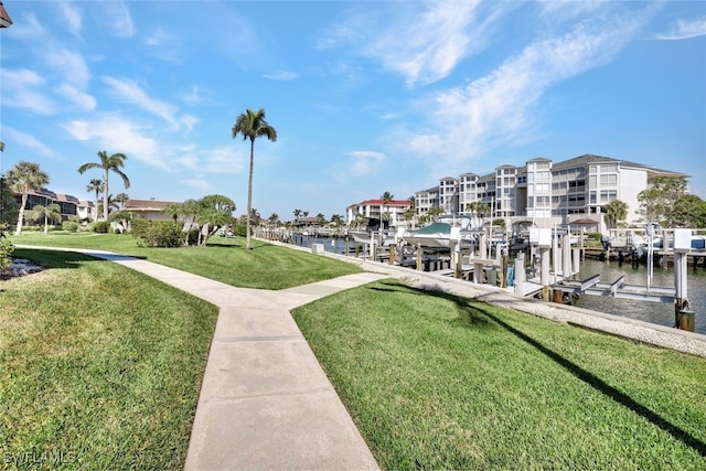 view of dock with a water view and a lawn