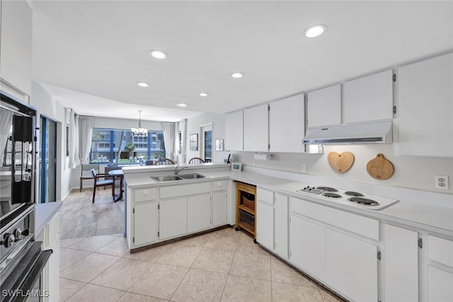 kitchen featuring decorative light fixtures, white cooktop, white cabinetry, and sink