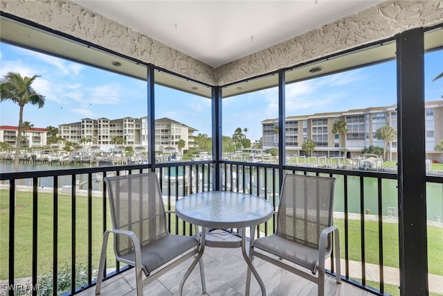 sunroom featuring a water view