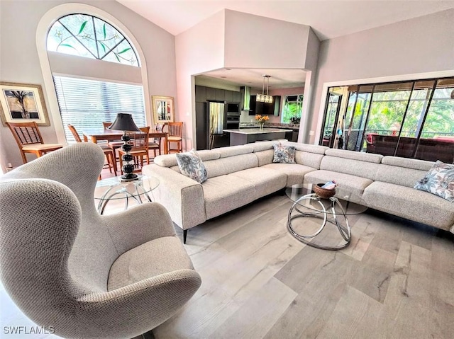 living room with a high ceiling and light hardwood / wood-style floors