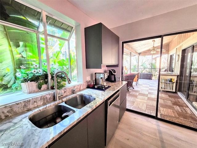 kitchen featuring dishwasher, light hardwood / wood-style floors, light stone counters, and sink