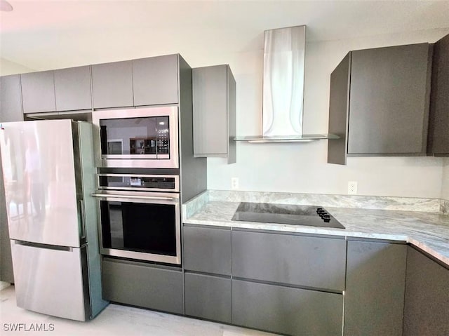 kitchen with appliances with stainless steel finishes, gray cabinetry, and wall chimney range hood