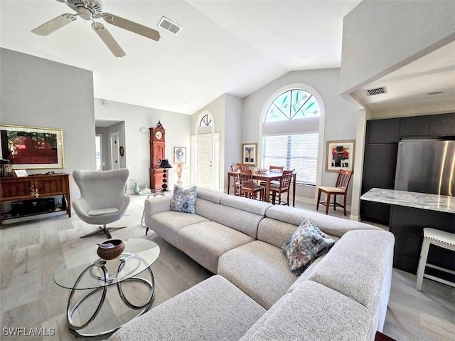 living room with ceiling fan, wood-type flooring, and vaulted ceiling