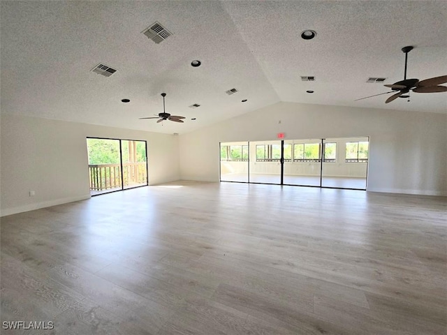 empty room with a textured ceiling, light hardwood / wood-style flooring, ceiling fan, and lofted ceiling