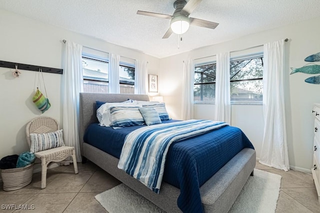 tiled bedroom with a textured ceiling and ceiling fan