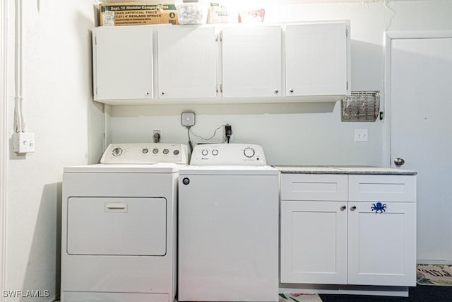 clothes washing area with washer and dryer and cabinets