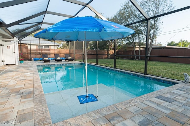 view of pool with a lawn, glass enclosure, and a patio area