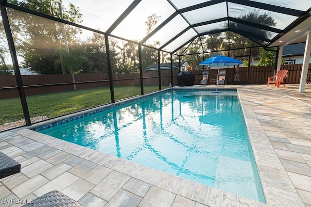 view of swimming pool featuring a patio, a lanai, and a lawn