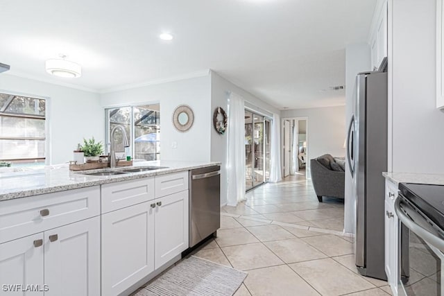 kitchen with white cabinetry, sink, light stone counters, and appliances with stainless steel finishes