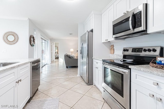 kitchen featuring light stone countertops, white cabinetry, light tile patterned flooring, and stainless steel appliances