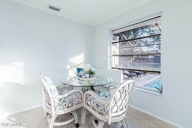 tiled dining space featuring crown molding and a wealth of natural light