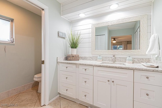 bathroom with ceiling fan, tile patterned flooring, vanity, and toilet