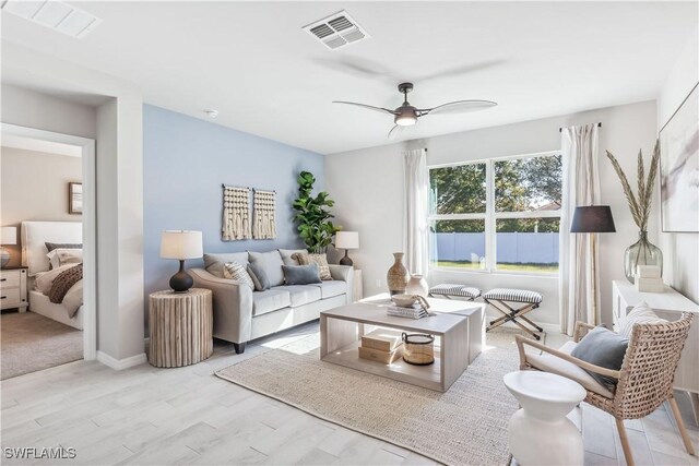 living room with ceiling fan and light hardwood / wood-style flooring