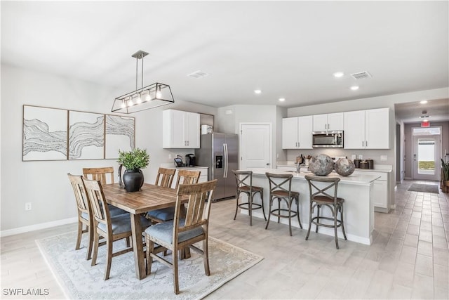 dining room featuring light wood-type flooring, baseboards, visible vents, and recessed lighting