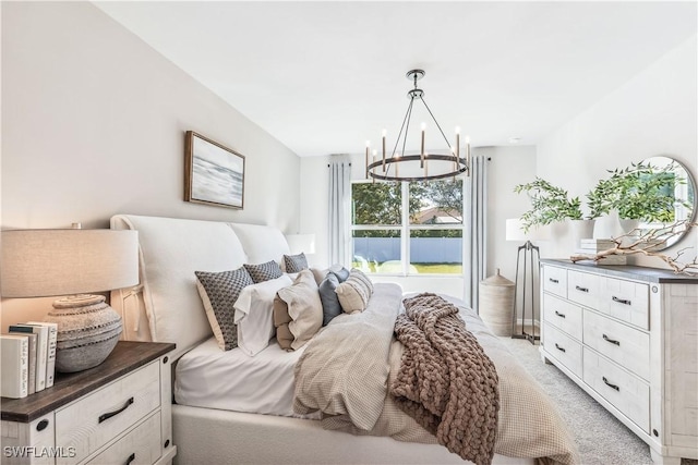 bedroom with a chandelier and light colored carpet