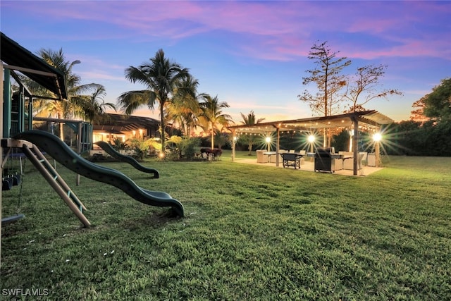 yard at dusk featuring an outdoor hangout area, a playground, and a patio