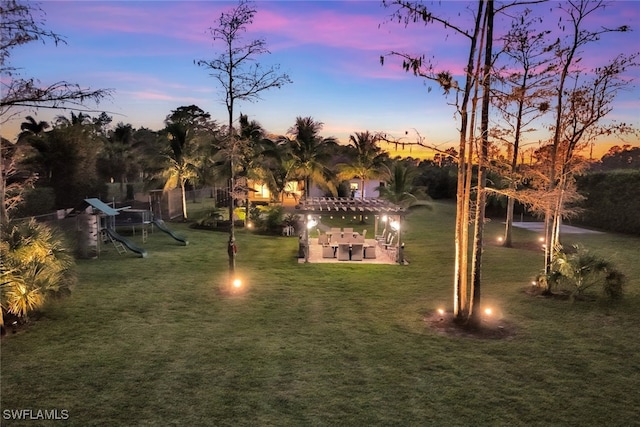 yard at dusk with a pergola and a playground