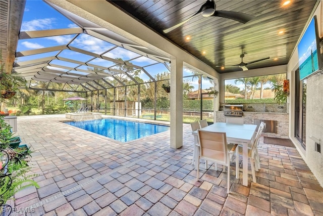 view of swimming pool with ceiling fan, an outdoor kitchen, grilling area, an in ground hot tub, and a patio