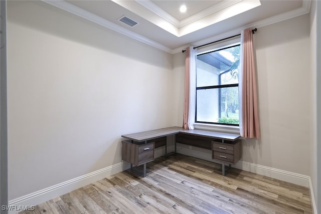 office featuring a tray ceiling, crown molding, and light hardwood / wood-style flooring