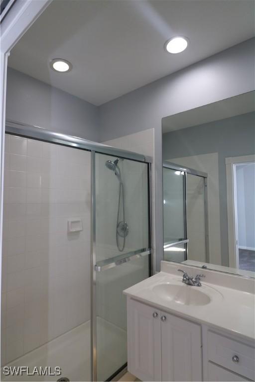 bathroom with vanity and a shower with shower door