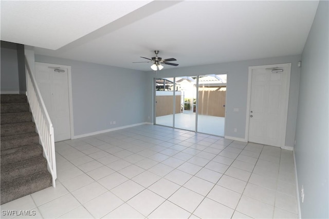 spare room with ceiling fan and light tile patterned floors