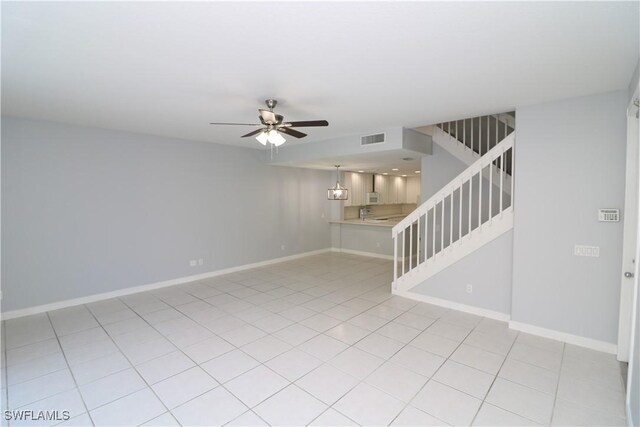 tiled empty room featuring ceiling fan