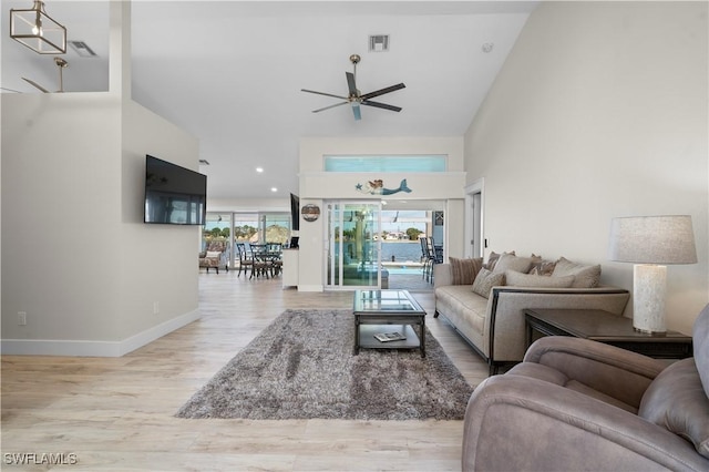 living room with light hardwood / wood-style floors, vaulted ceiling, and ceiling fan