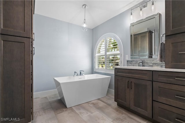 bathroom with a washtub, vanity, and tasteful backsplash