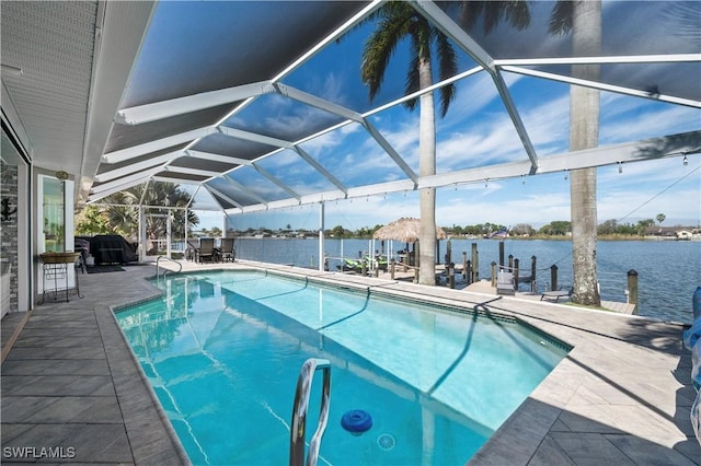 view of swimming pool featuring glass enclosure, a patio area, a water view, and a boat dock