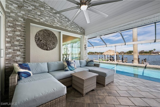 view of patio featuring glass enclosure, a water view, and an outdoor living space