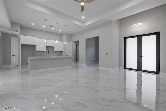 unfurnished living room with ceiling fan, french doors, and sink