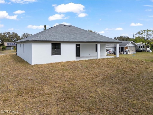 back of house with a yard and a patio