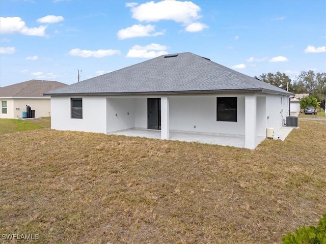 rear view of house with a lawn, cooling unit, and a patio