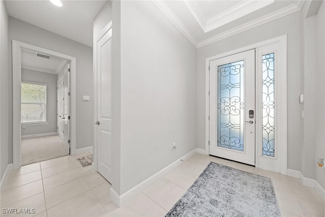 entryway with light tile patterned floors and ornamental molding