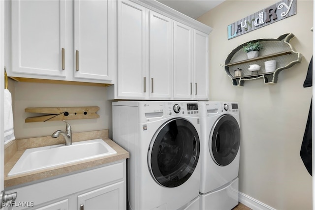 clothes washing area featuring cabinets, separate washer and dryer, and sink