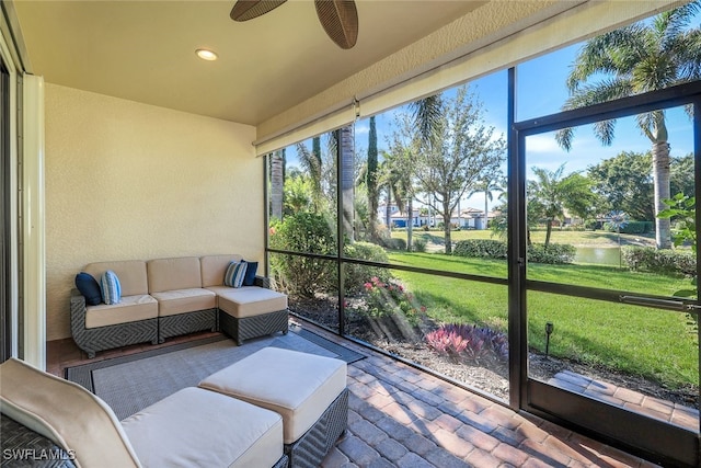 sunroom with ceiling fan, plenty of natural light, and a water view