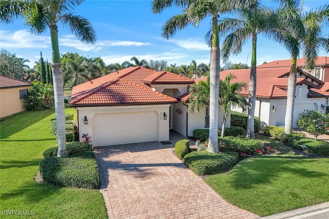 mediterranean / spanish-style house featuring a garage and a front lawn