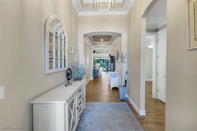 hall featuring light hardwood / wood-style floors, crown molding, and a notable chandelier