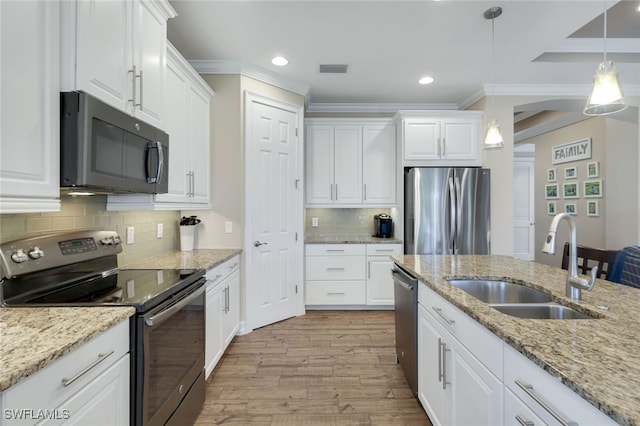 kitchen with white cabinets, pendant lighting, stainless steel appliances, and sink