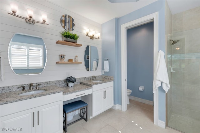 bathroom featuring tile patterned flooring, a shower with door, vanity, and toilet