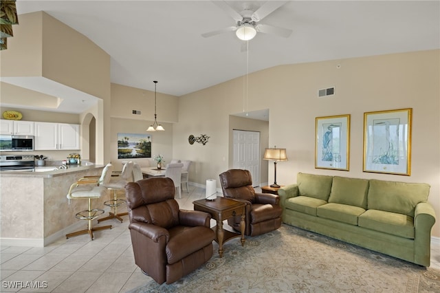 tiled living room with ceiling fan and lofted ceiling