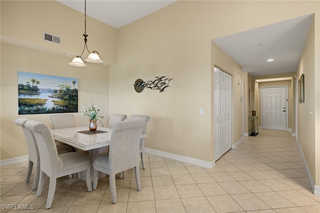 dining space featuring light tile patterned flooring and a notable chandelier