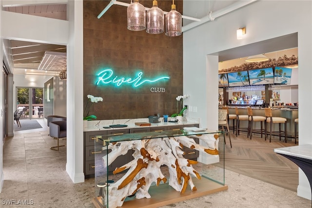 bar with parquet flooring and a towering ceiling