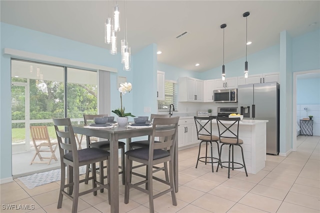 tiled dining room with sink and high vaulted ceiling