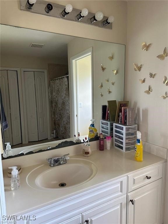 bathroom with curtained shower and vanity