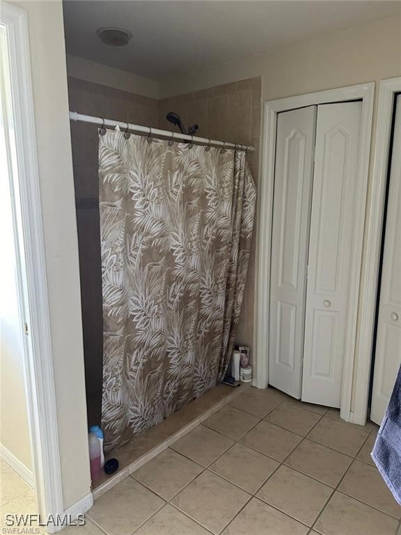 bathroom with tile patterned floors and walk in shower